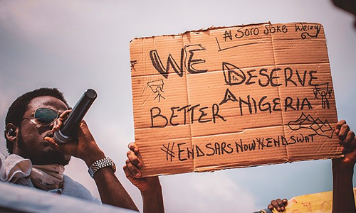 Street protest and sign saying "we deserve a better Nigeria"