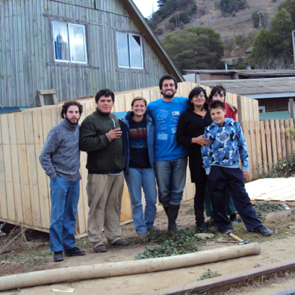 GLBL Student standing with people in front of house