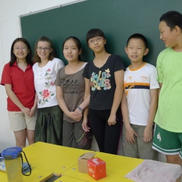 GLBL student standing with a group in a classroom