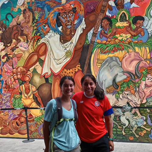 Two students standing in front of a mural in Costa Rica