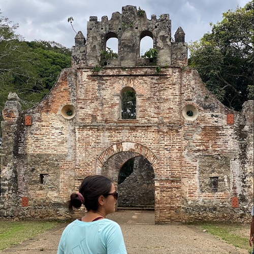 Student standing in front of architectural ruins in Costa Rica